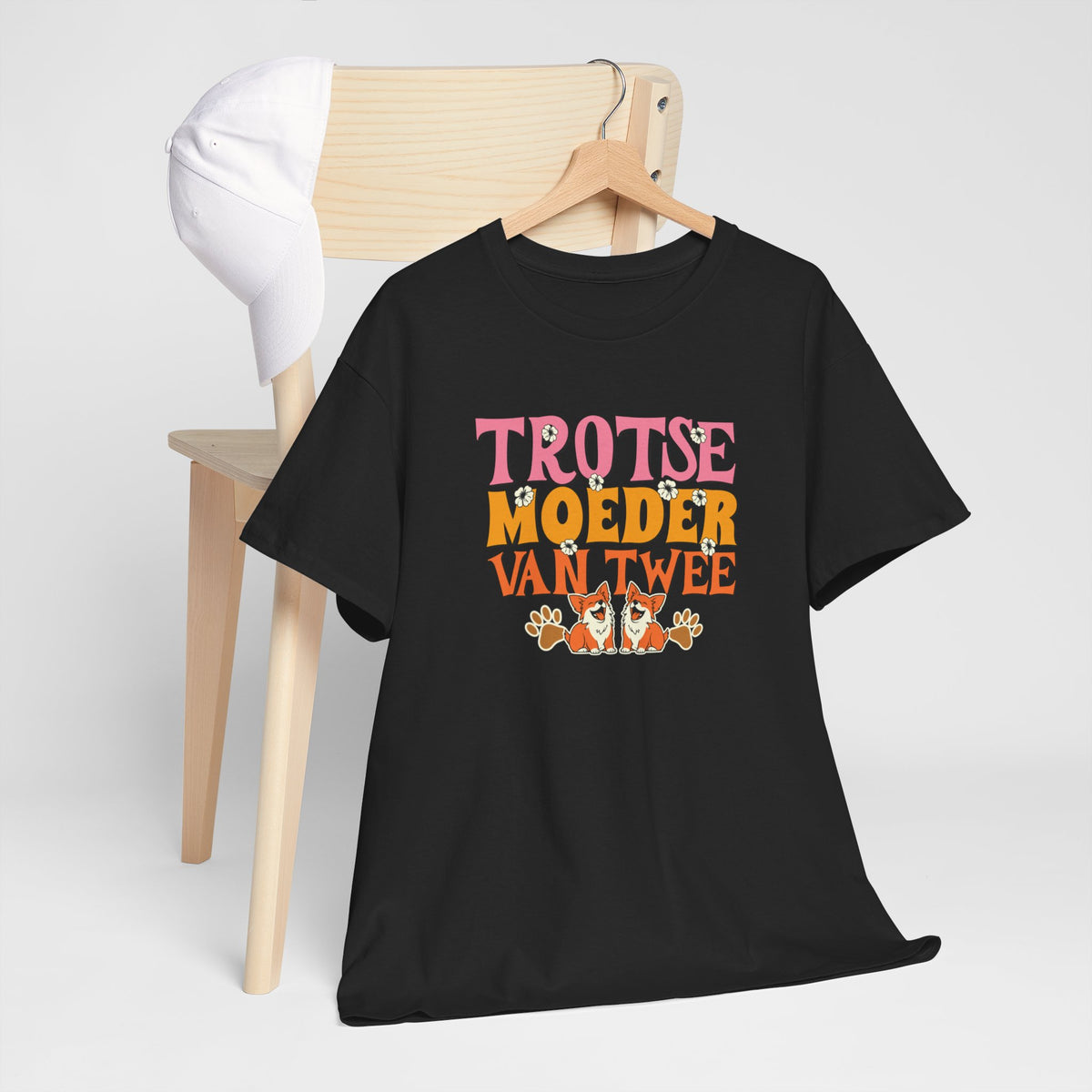 Zwarte t-shirt met kleurrijke tekst en honden/kattenprint op de borst, op een hanger.