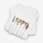 Wit T-shirt met bloemenillustratie en sierlijke namen langs de bloemenstelen.