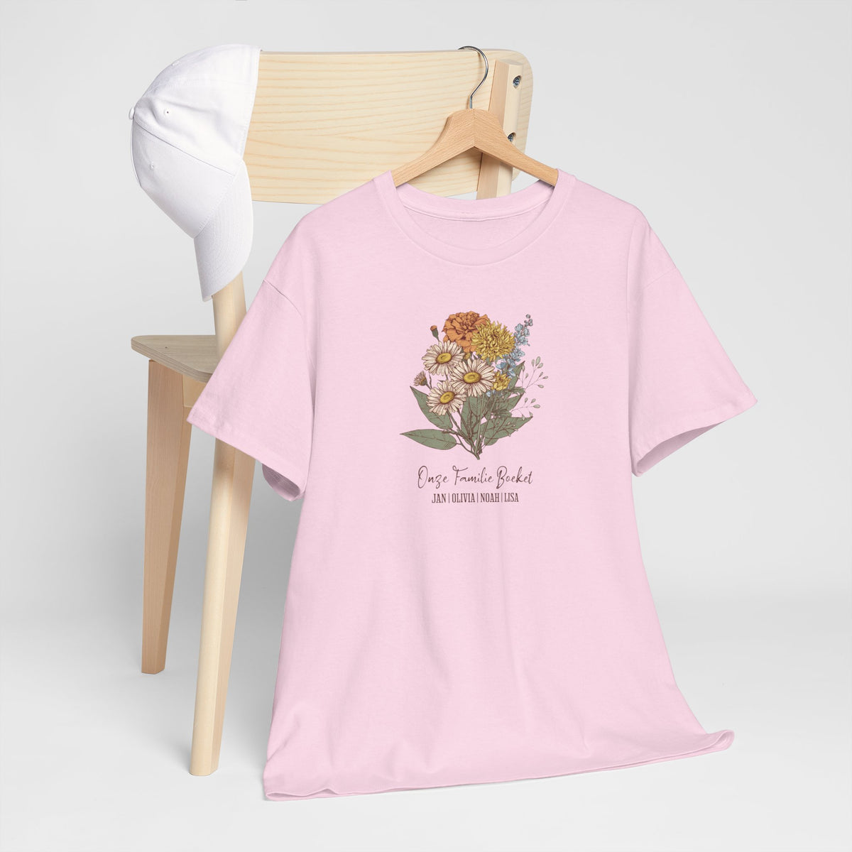 Roze T-shirt met bloemboeketprint op borst, korte mouwen, op houten hanger.