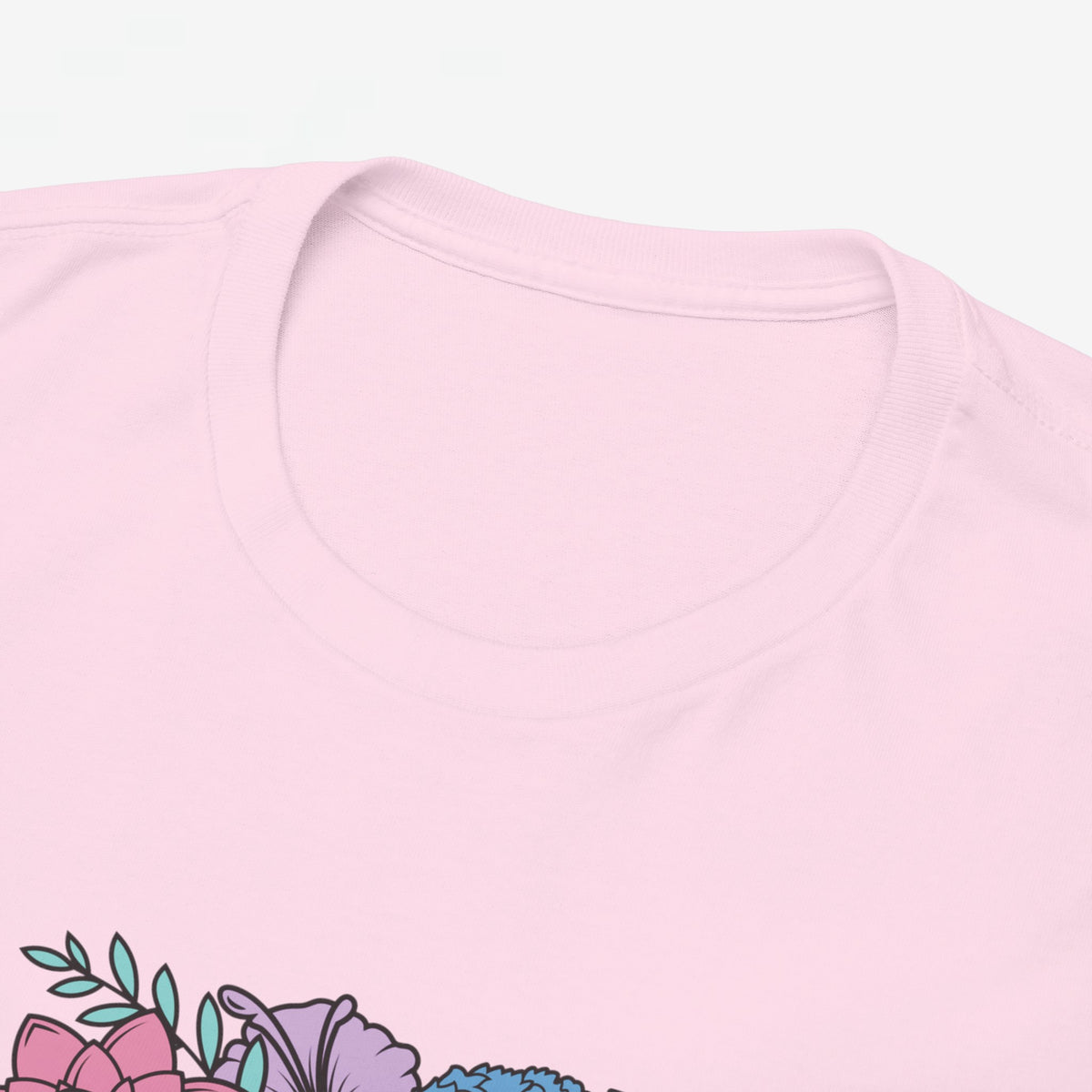 Roze T-shirt close-up: ronde hals en deel van bloemenprint op de borst.