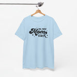 Lichtblauwe t-shirt aan een houten hanger met zwarte "In My Mom Era"-print.