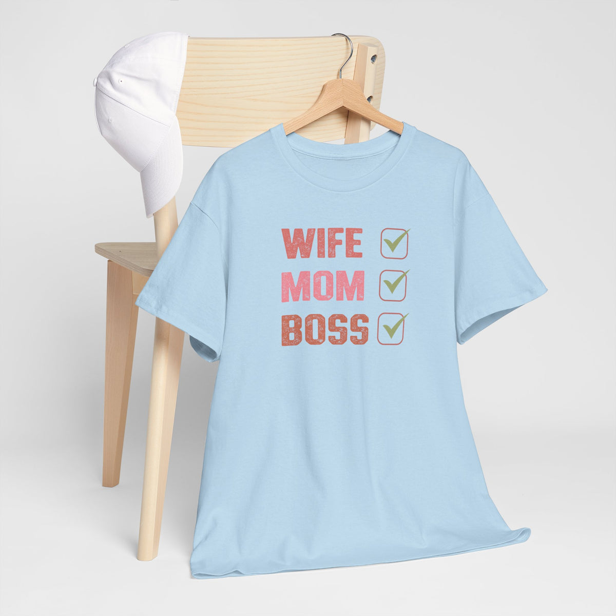 Lichtblauwe T-shirt op hanger met ronde hals en opdruk “WIFE MOM BOSS” met check-icoontjes.