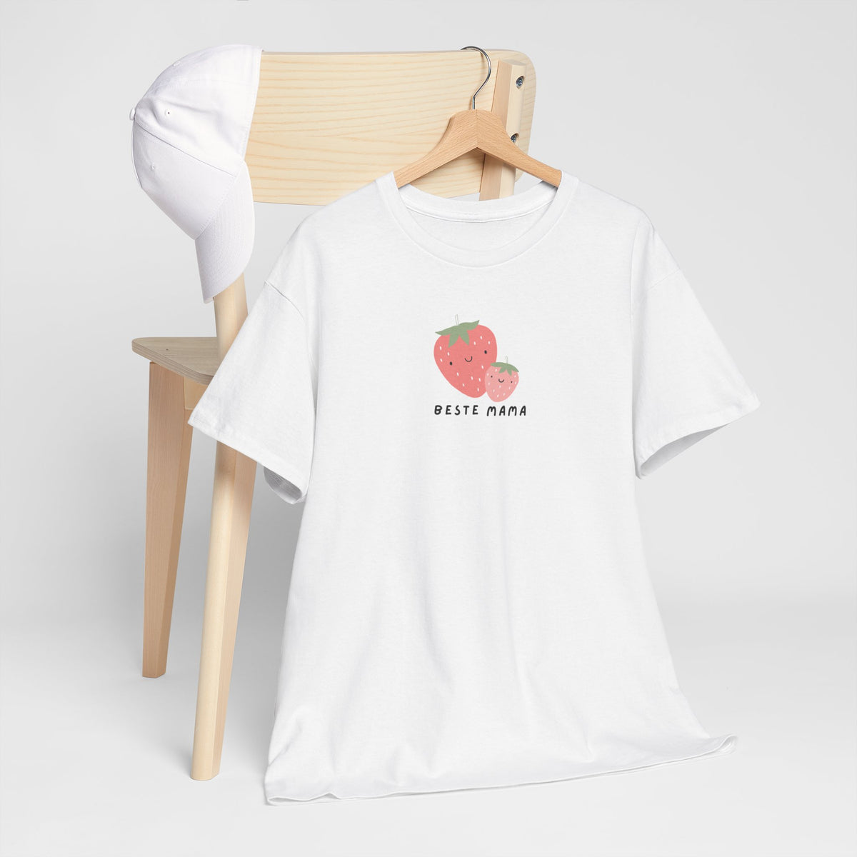 Wit t-shirt op houten hanger met aardbei-print en “Beste Mama” op de borst