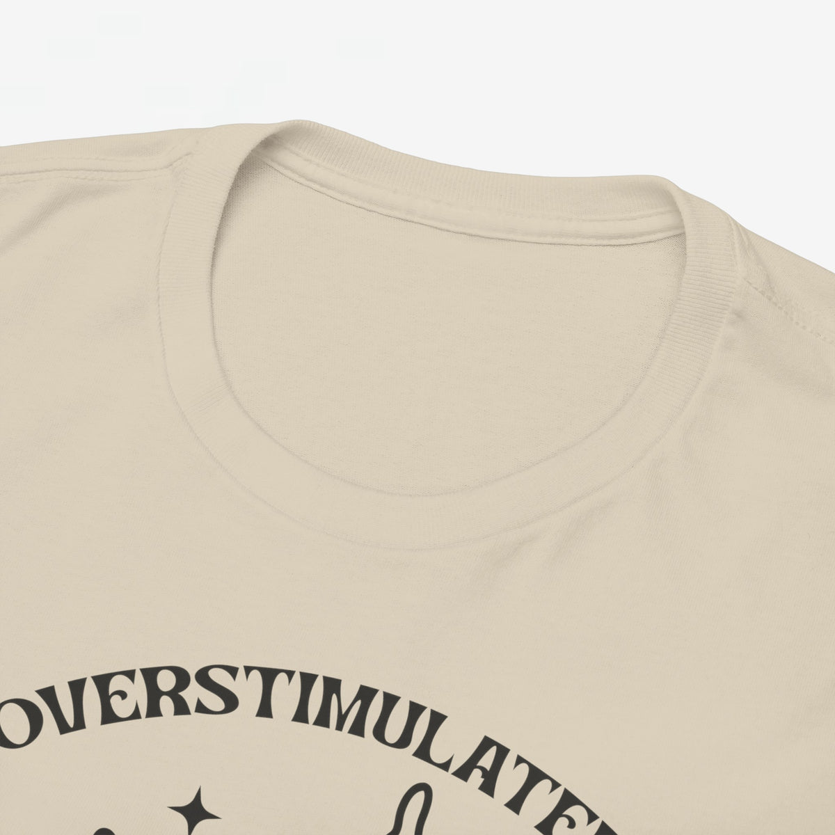 Zandkleurige T-shirt hals en schouder; close-up van neknaad en deel van print
