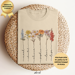 Beige T-shirt met geboortemaand bloemenprint en wikkelmand, label met tekst skrrt.
