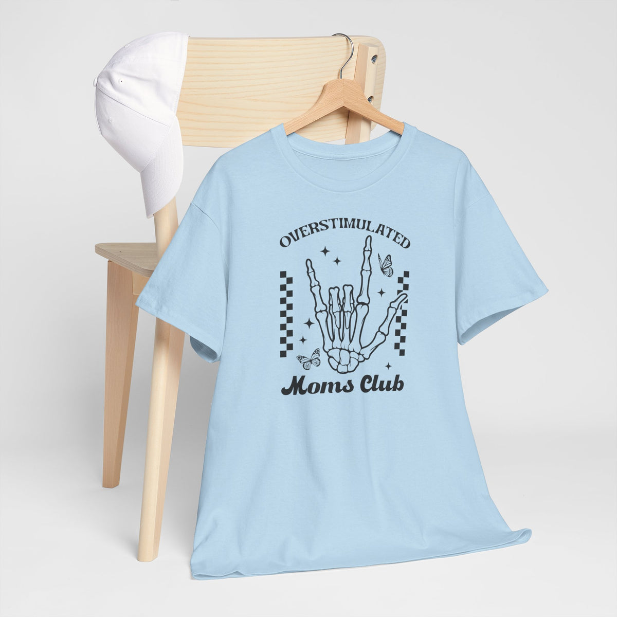 Lichtblauw T-shirt met handgraphic en “Overstimulated Moms Club” op houten hanger