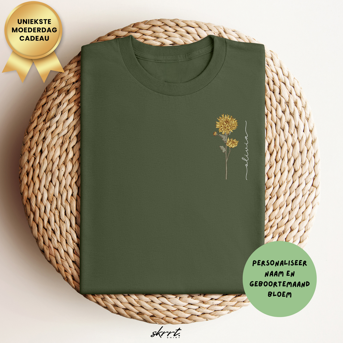 Donkergroen T-shirt met ronde hals en kleine goudkleurige bloemprint op de borst.