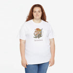 Wit T-shirt met bloemenboeketprint op de borst, gedragen door een vrouw.