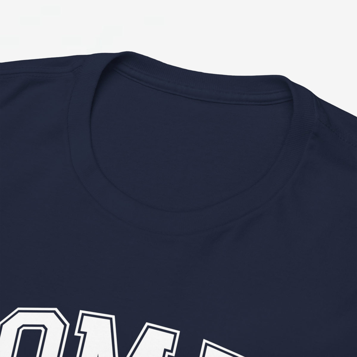 Donkerblauw T-shirt met ronde hals en bovenkant van “OMA” opdruk zichtbaar.