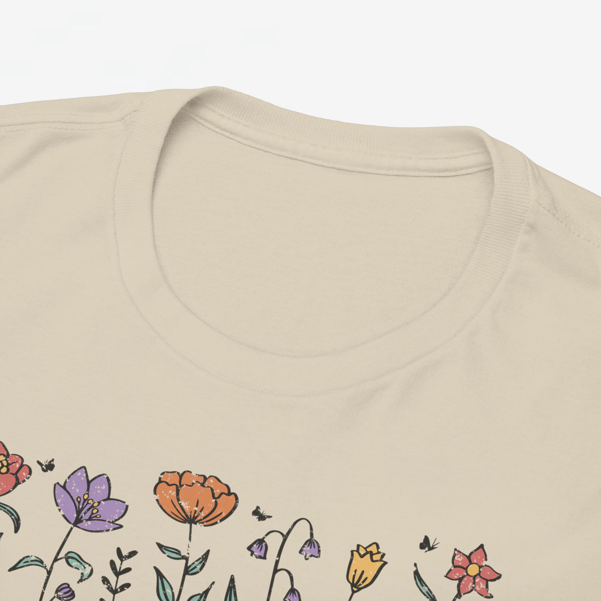Beige T-shirt close-up: ronde hals en deels zichtbare bloemen-'Mama' opdruk.