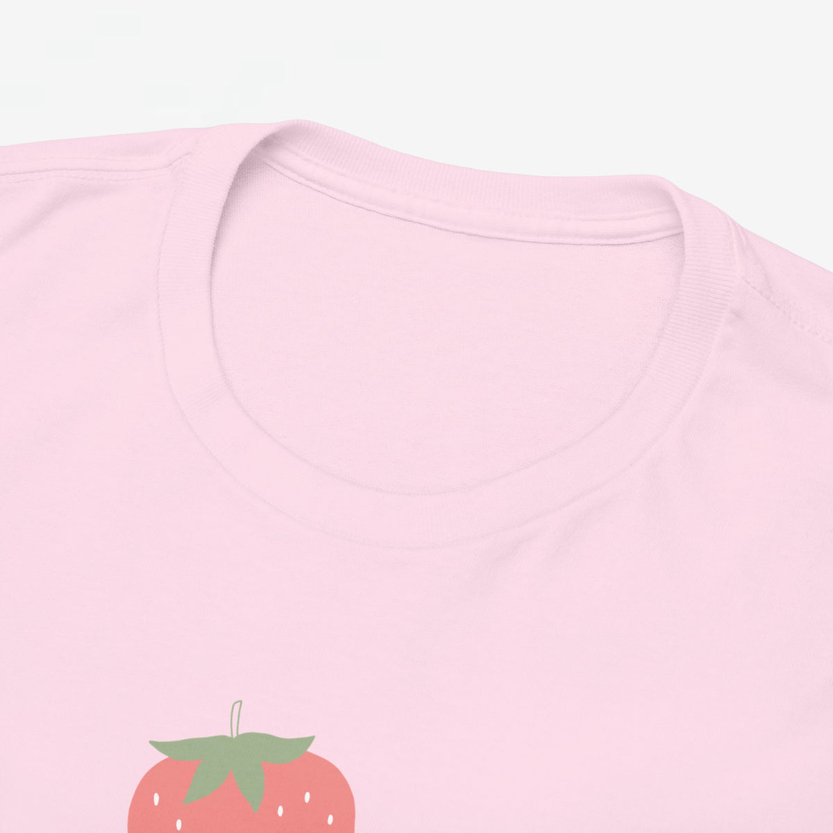 Roze T-shirt halsdetail met subtiele kraagnaad en deel van aardbeienprint.