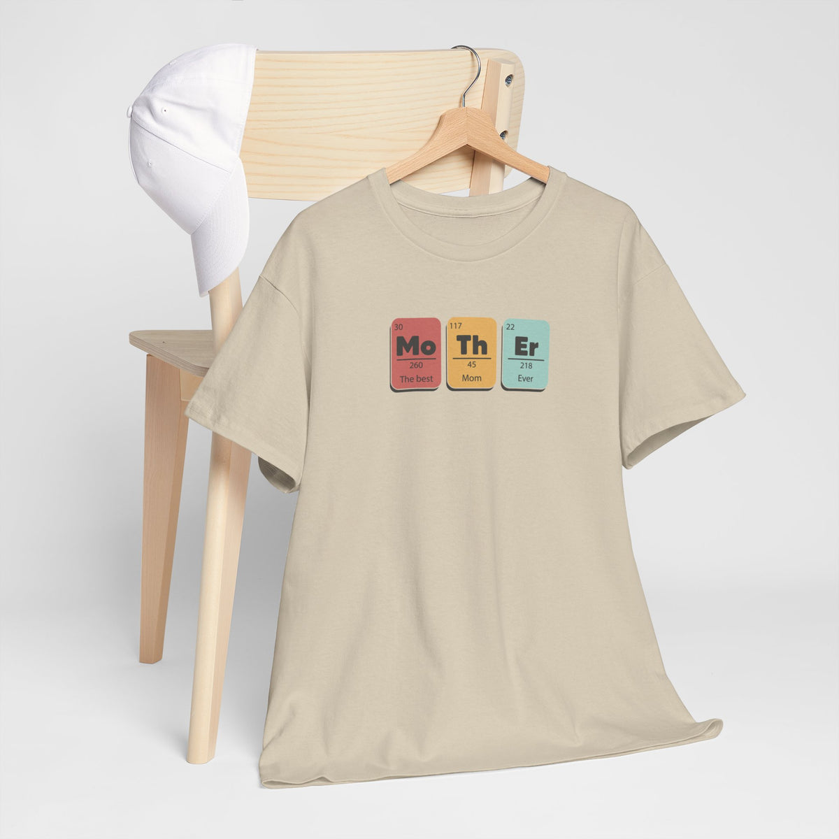 Zandkleurige T-shirt met ronde hals en borstprint, hangend aan houten hanger
