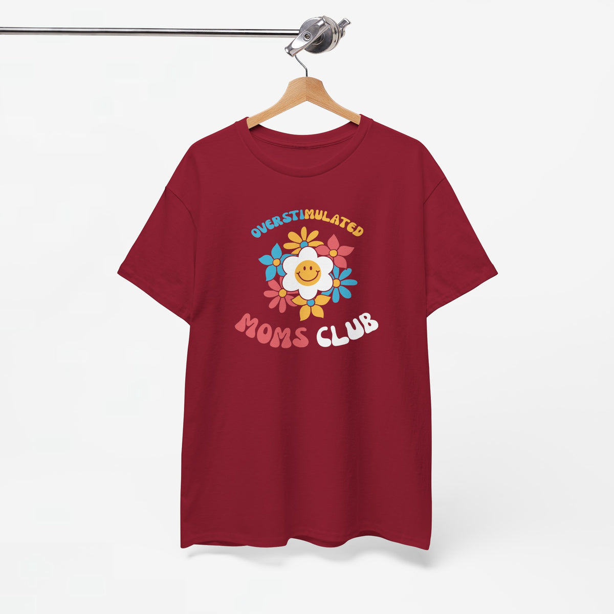 Bordeauxrode t-shirt aan houten hanger met borstprint “Overstimulated Moms Club” en bloemenleeuw-logo
