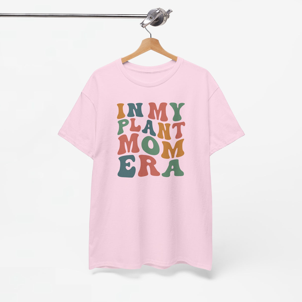 Roze T-shirt aan een hanger, met ronde hals en multikleurenprint “IN MY PLANT MOM ERA”.