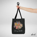 Zwarte tote bag met bloemenboeket en naam Elizabeth, bovenaanzicht met gevouwen hengsel.