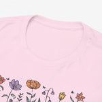 Detail van T-shirt lichtroze: ronde hals en bloemenprint met deel van "MAMA" letters