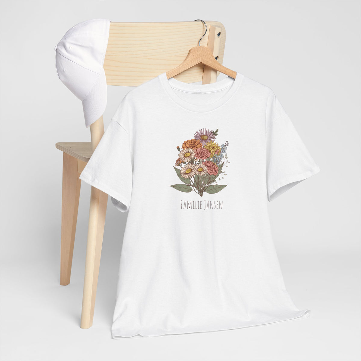 Wit T-shirt met bloemenboeketprint en “FAMILIE JANSEN”, op kledinghanger