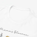 Close-up: witte T-shirt hals met subtiele opdruk “Mama's Bloemen”.