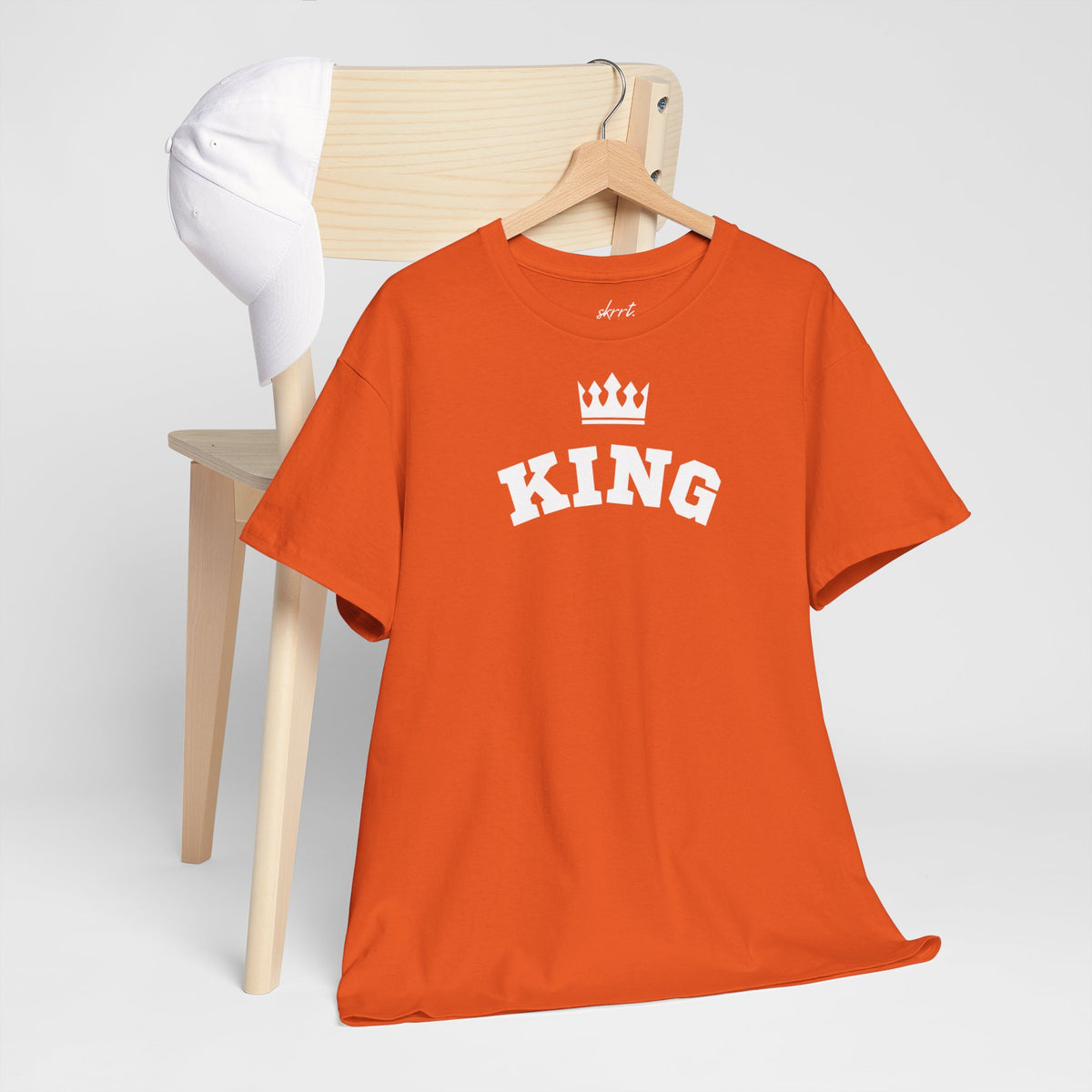 Oranje T-shirt op houten hangertje met “KING”-print en kroon