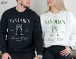 Twee sweatshirts: zwarte en witte met opdruk VAN DIJK'S Social Club en champagneglazen