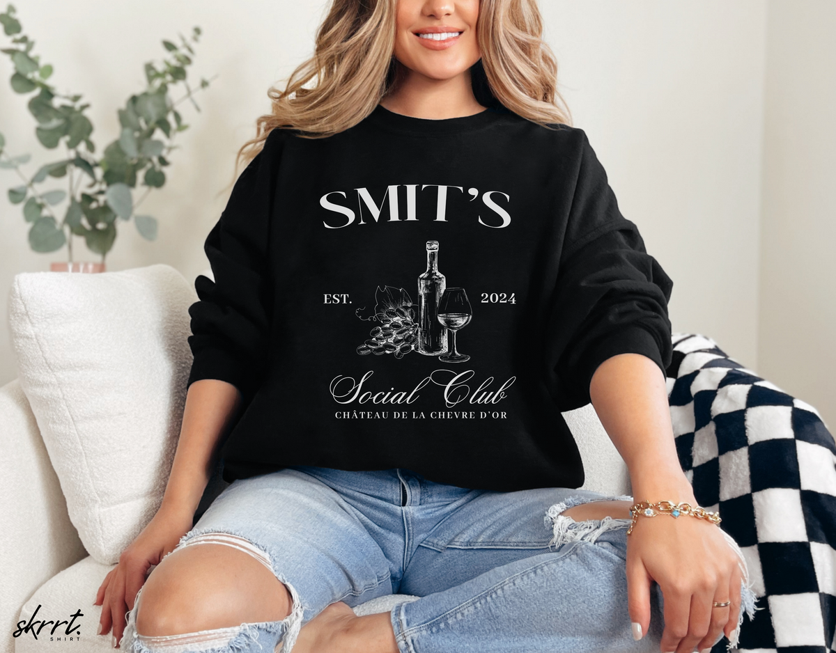 Zwarte sweatshirt op model met “SMIT’S Social Club” print en fles/glas
