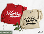 Set gepersonaliseerde sweatshirts rood “Hubby” en beige “Wifey”, beide met “EST. 2024”
