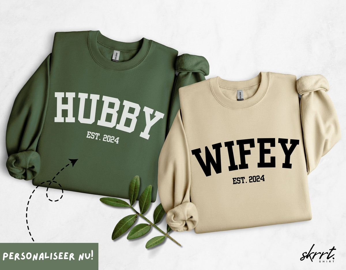Koppelset truien: groene 'HUBBY' en beige 'WIFEY', elk met 'EST. 2024'.