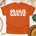 Oranje T-shirt platgelegd met witte “ORANJE GEKTE” frontprint en ronde hals